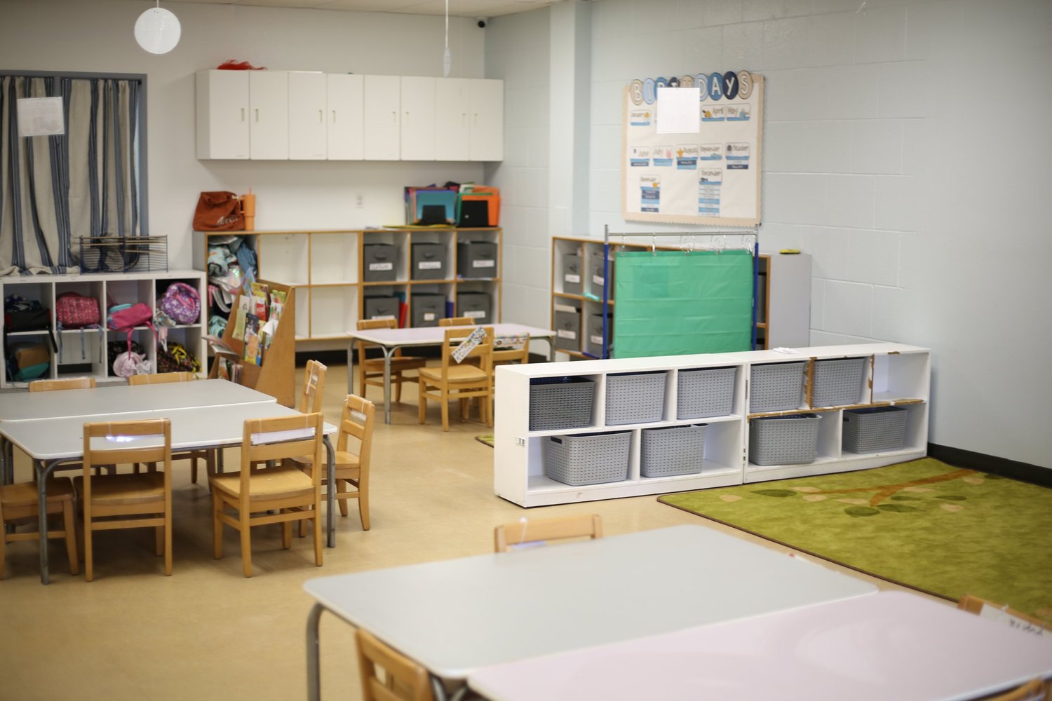 A welcoming Golden Poppy classroom with child-sized tables, natural light, and learning shelves